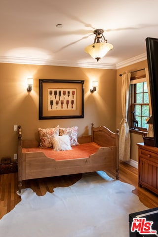 bedroom with crown molding and wood-type flooring