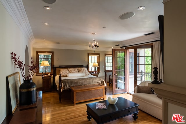 bedroom with crown molding, access to outside, a chandelier, and light wood-type flooring