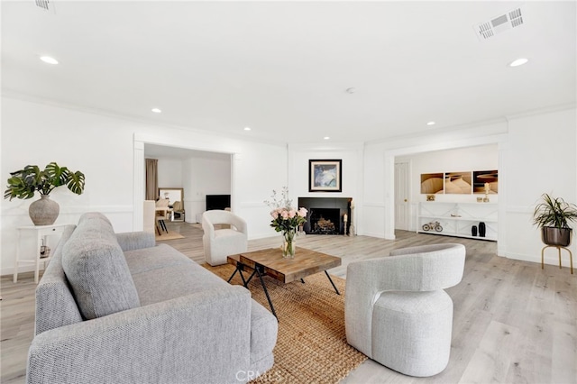 living room featuring light hardwood / wood-style flooring and ornamental molding