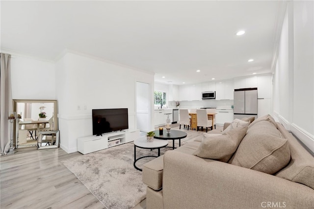 living room featuring crown molding and light hardwood / wood-style floors