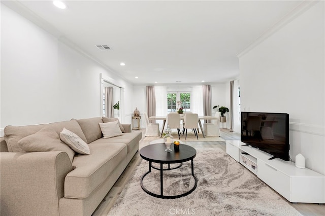 living room featuring light hardwood / wood-style floors and ornamental molding