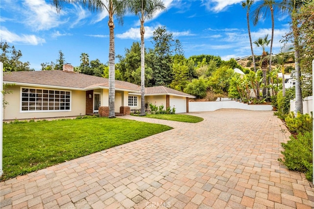 ranch-style house with a garage and a front lawn