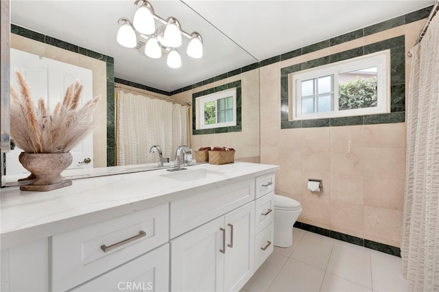 bathroom with tile walls, tile patterned floors, vanity, and toilet