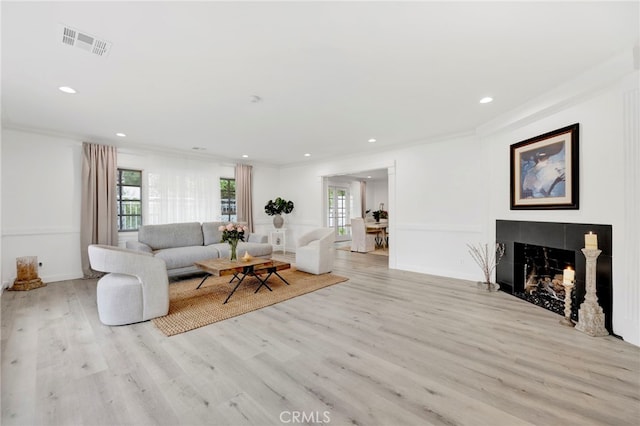 living room featuring crown molding and light wood-type flooring