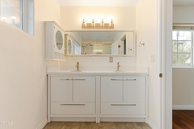 bathroom featuring a shower with shower door and vanity