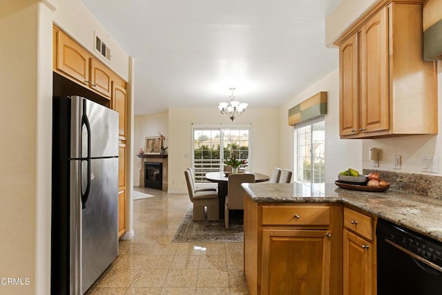 kitchen with stone countertops, dishwasher, hanging light fixtures, a chandelier, and stainless steel refrigerator