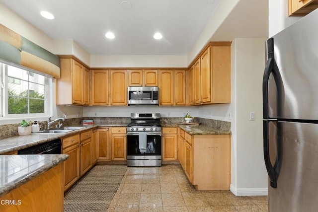 kitchen featuring sink, dark stone countertops, and appliances with stainless steel finishes