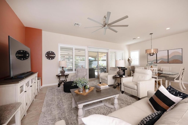 living room featuring ceiling fan with notable chandelier