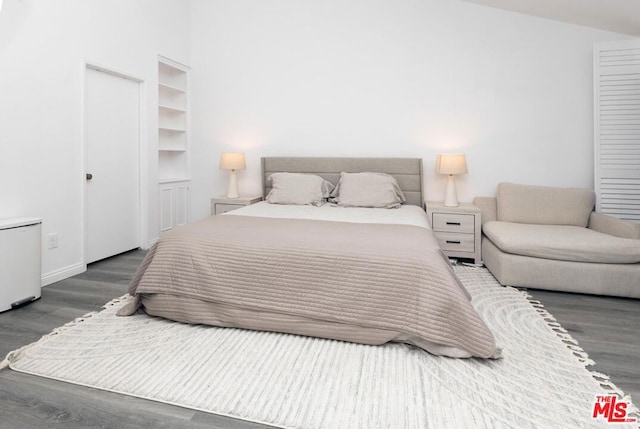 bedroom with dark hardwood / wood-style flooring