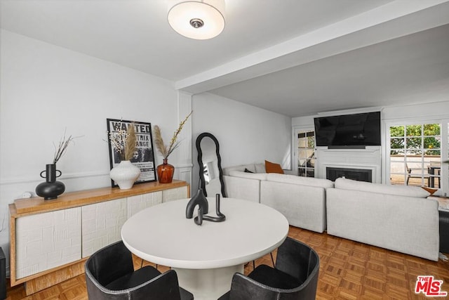 dining room featuring dark parquet floors and a fireplace