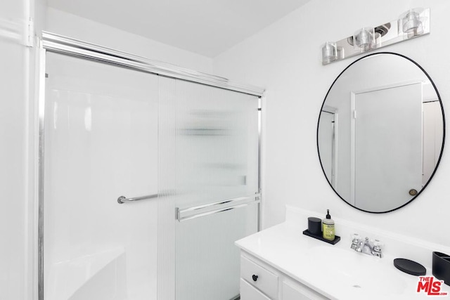 bathroom with vanity and a shower with shower door