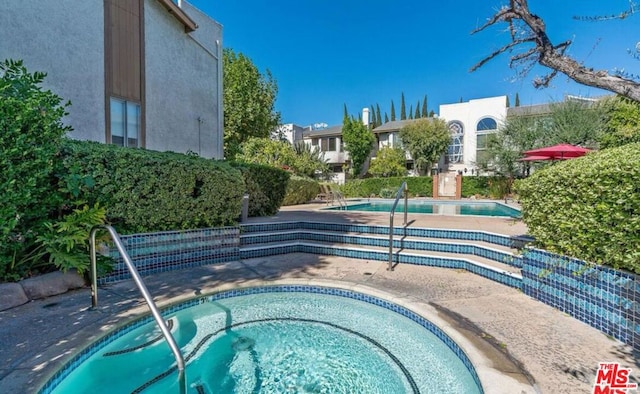 view of swimming pool featuring a community hot tub