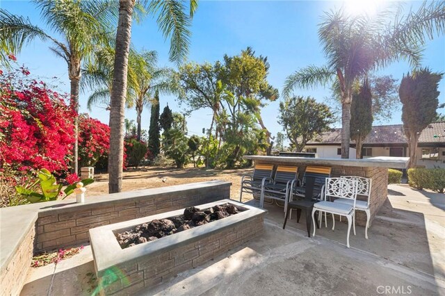 view of patio with an outdoor bar and a fire pit