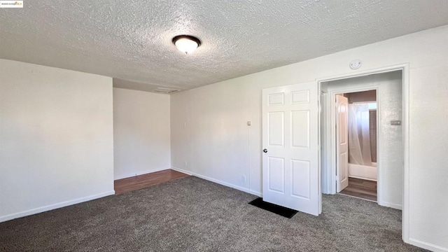 carpeted empty room featuring a textured ceiling