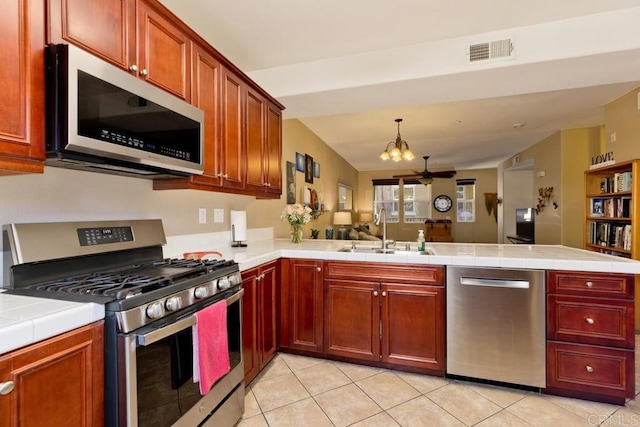 kitchen featuring sink, tile counters, kitchen peninsula, and stainless steel appliances