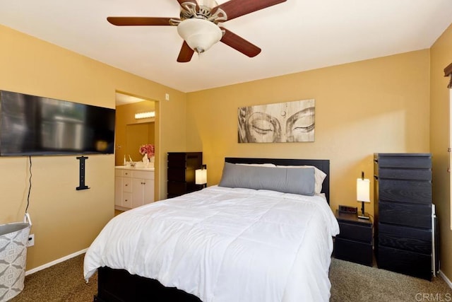 bedroom with dark carpet, ensuite bath, and ceiling fan