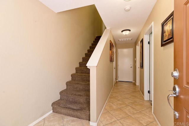 interior space with stairs, visible vents, baseboards, and light tile patterned flooring