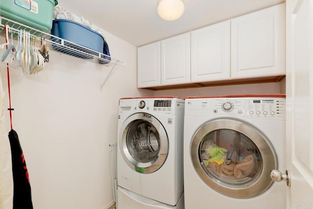 laundry area featuring washer and clothes dryer and cabinet space