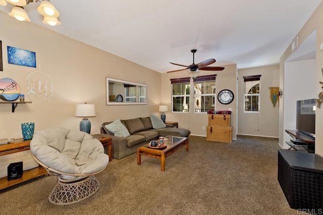 carpeted living area featuring ceiling fan with notable chandelier, visible vents, and baseboards