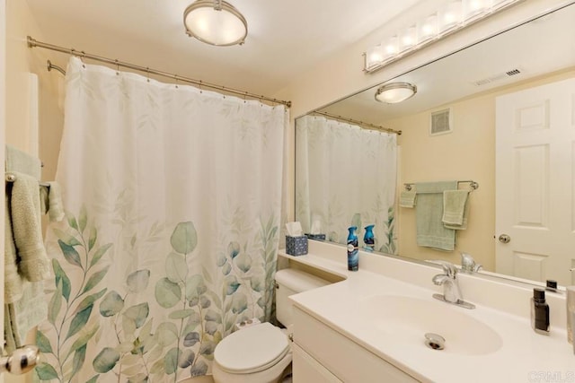 bathroom featuring curtained shower, visible vents, vanity, and toilet