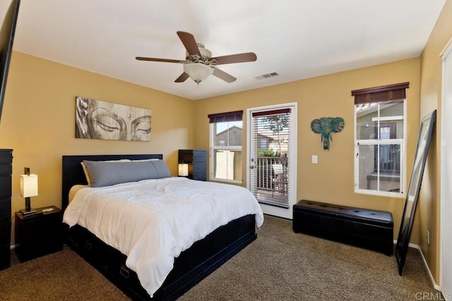 carpeted bedroom with access to exterior, visible vents, and a ceiling fan