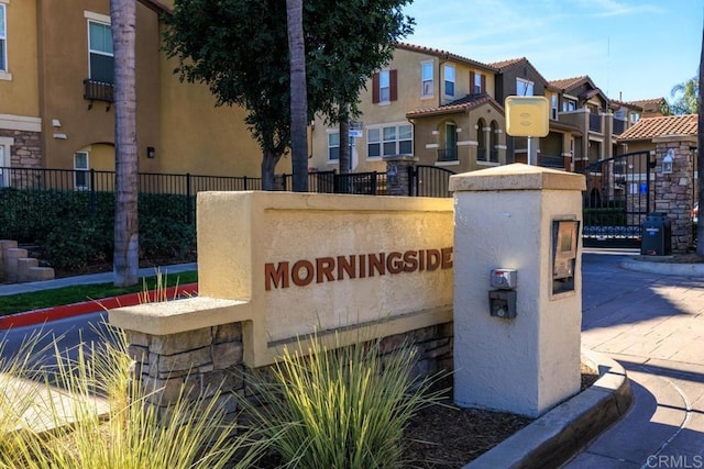 community sign featuring fence and a residential view