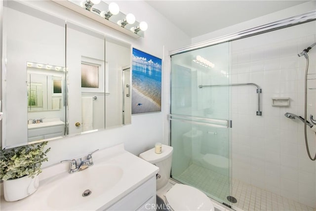 bathroom with toilet, walk in shower, and vanity