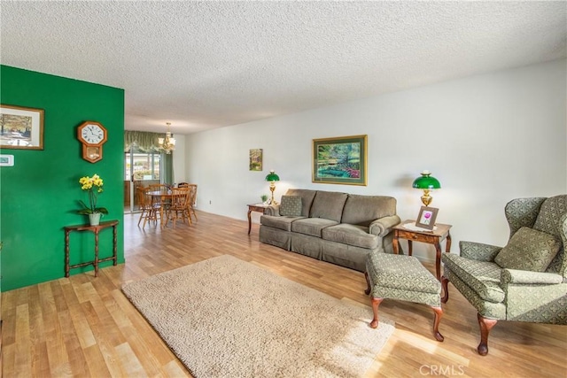 living room featuring hardwood / wood-style floors, a textured ceiling, and a chandelier