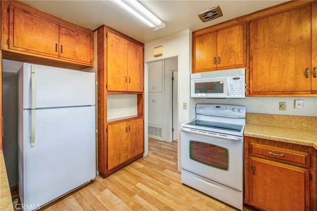 kitchen featuring white appliances and light hardwood / wood-style floors