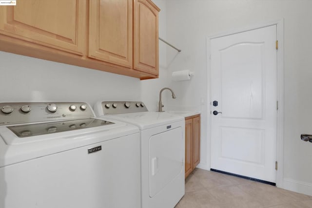 laundry area with sink, light tile patterned flooring, cabinets, and independent washer and dryer