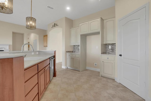 kitchen with tasteful backsplash, dishwasher, hanging light fixtures, light tile patterned floors, and sink