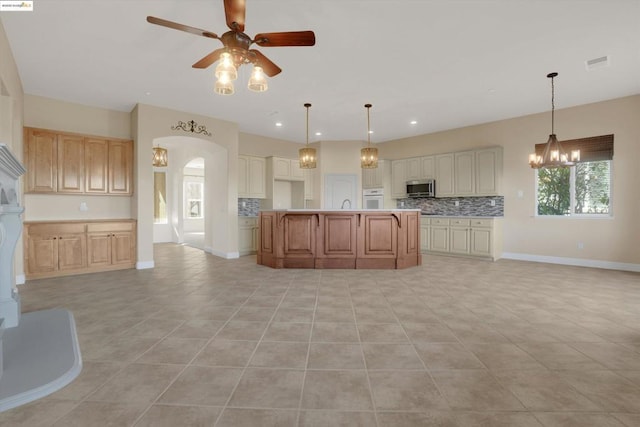 kitchen with white oven, a center island, tasteful backsplash, hanging light fixtures, and light tile patterned flooring