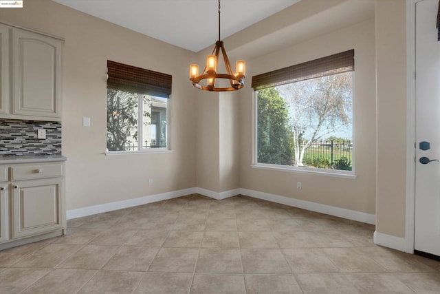 unfurnished dining area featuring a notable chandelier and light tile patterned flooring