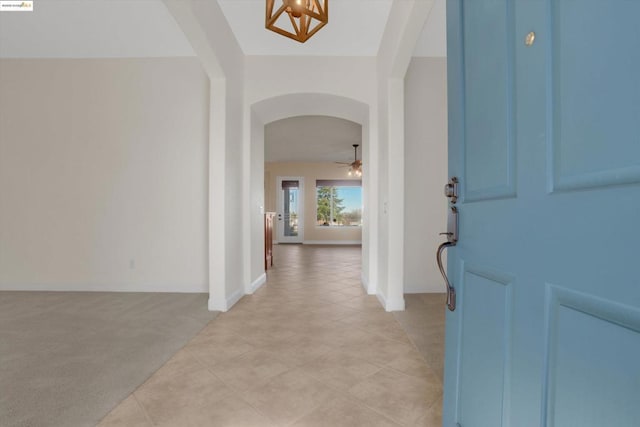 carpeted foyer entrance featuring ceiling fan