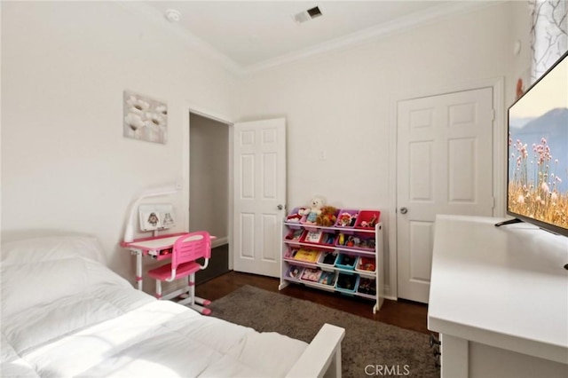 bedroom with visible vents, crown molding, and wood finished floors