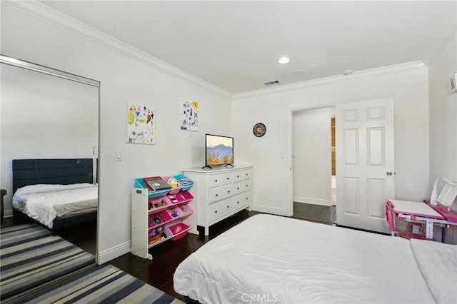 bedroom featuring dark wood finished floors, visible vents, baseboards, and ornamental molding