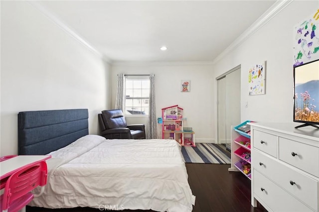 bedroom with a closet, crown molding, and dark hardwood / wood-style floors