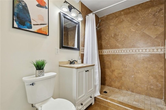 full bath featuring toilet, vanity, and a tile shower