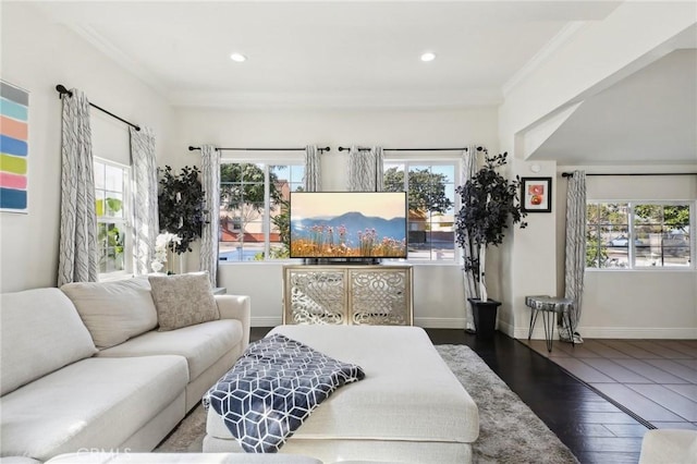 living room with crown molding, baseboards, and wood finished floors