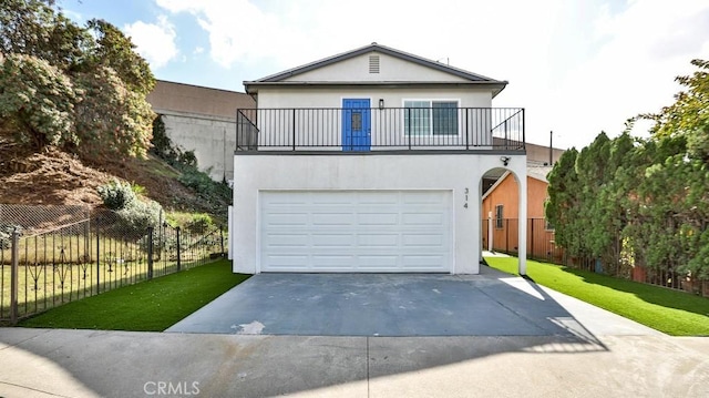 view of front of home featuring a balcony, a front yard, fence, and stucco siding