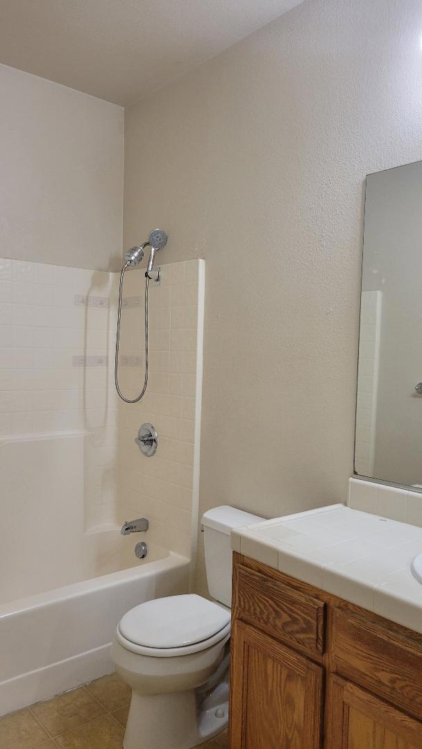 full bathroom featuring vanity, bathing tub / shower combination, tile patterned floors, and toilet