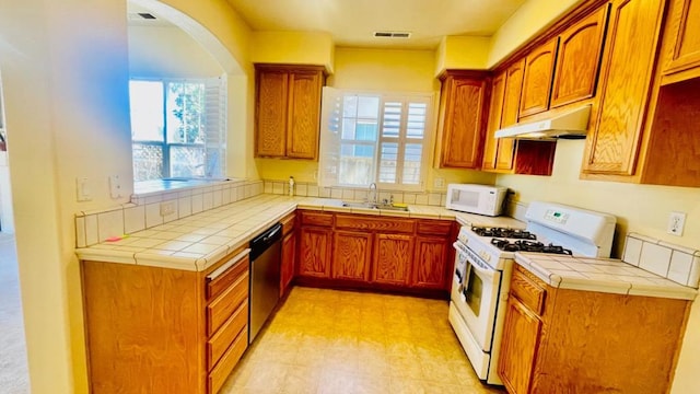 kitchen featuring sink, tile countertops, and white appliances