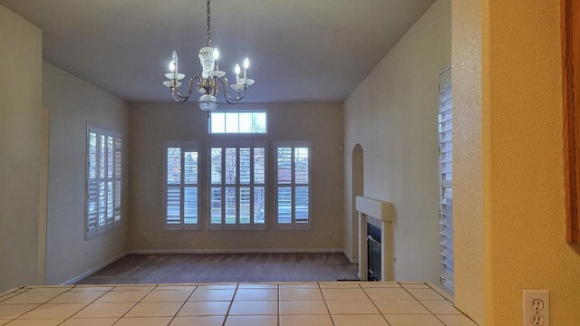 unfurnished living room with light tile patterned floors and an inviting chandelier