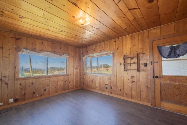 spare room featuring wooden walls, dark hardwood / wood-style floors, and wooden ceiling