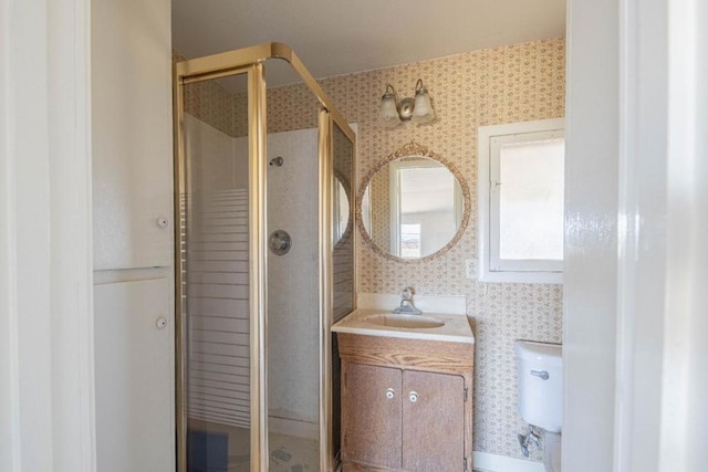 bathroom featuring toilet, an enclosed shower, and vanity