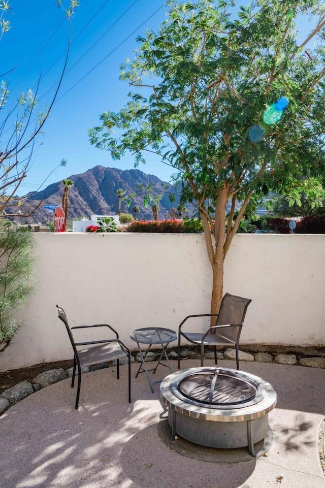 view of patio / terrace featuring a mountain view and an outdoor fire pit