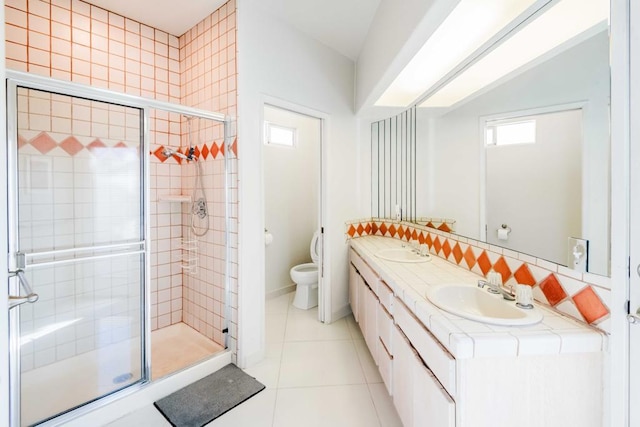 bathroom with decorative backsplash, tile patterned flooring, vanity, toilet, and a shower with door