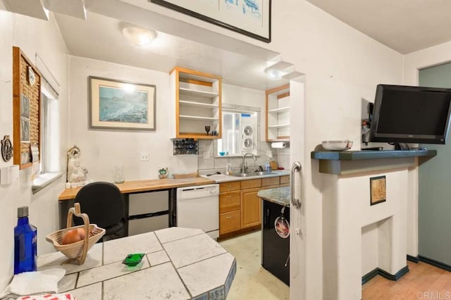 kitchen featuring sink, backsplash, light hardwood / wood-style floors, and white dishwasher