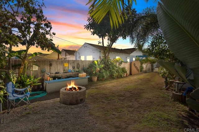 yard at dusk featuring a fire pit