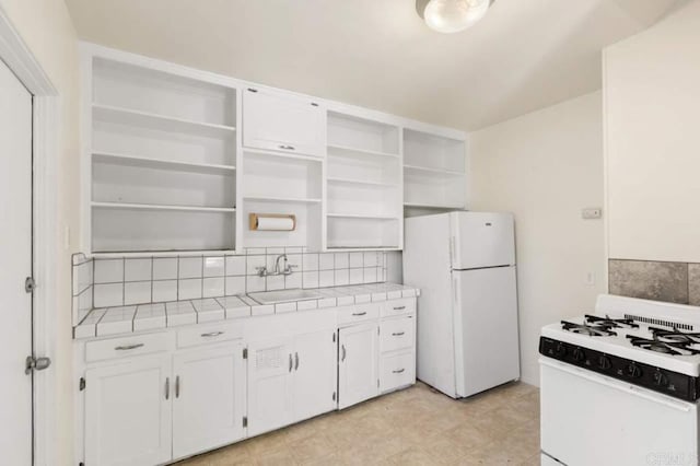 kitchen featuring white appliances, white cabinets, decorative backsplash, sink, and tile countertops